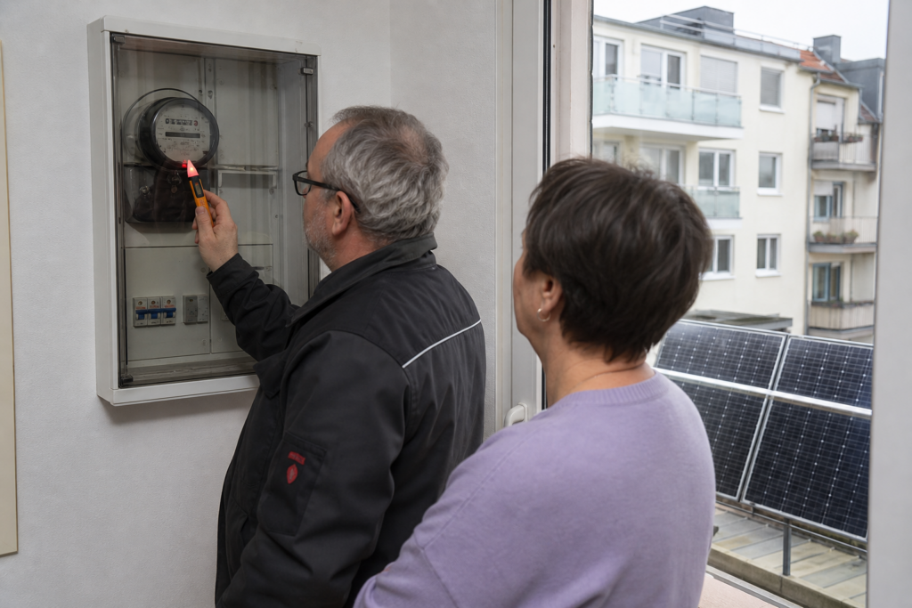 Elektriker prüft einen alten Stromzähler bei Betrieb eines Balkonkraftwerks [Bildinhalt mit KI erstellt]