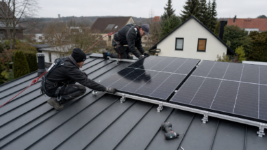 Installateure montieren Photovoltaikmodule auf einem Stehfalz-Metalldach [Bildinhalt mit KI erstellt]