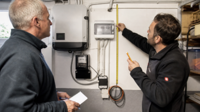 Hausbesitzer und Installateur vermessen den Einbauort für einen nachgerüsteten Solarspeicher [Bildinhalt mit KI erstellt]