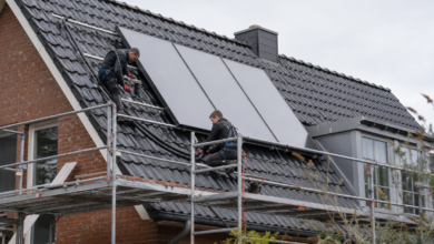 Installateure montieren Flachkollektoren sicher auf einem Wohnhausdach [Bildinhalt mit KI erstellt]