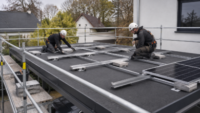 Gesicherte Installateure montieren eine ballastierte Photovoltaik-Unterkonstruktion auf einem Carport [Bildinhalt mit KI erstellt]