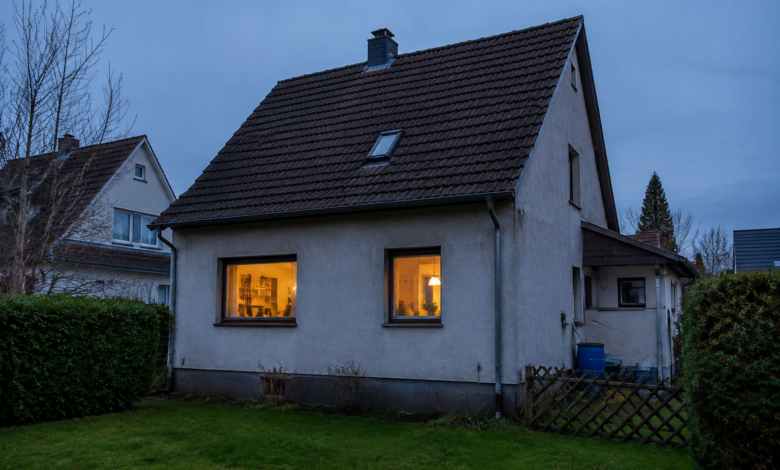 Bewohntes Einfamilienhaus mit dezent beleuchteten Fenstern am frühen Abend. [Bildinhalt mit KI erstellt]