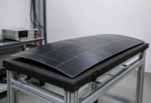 Leicht gewölbtes Photovoltaik-Prüfmuster auf einer gepolsterten Halterung im Labor. [Bildinhalt mit KI erstellt]
