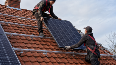 Gesicherte Solarinstallateure verlegen ein Photovoltaikmodul auf vorbereiteten Dachschienen [Bildinhalt mit KI erstellt]