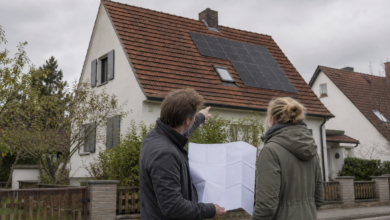 Hausbesitzerin und Planer prüfen eine Solaranlage auf einem Wohnhausdach [Bildinhalt mit KI erstellt]