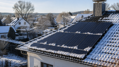 Photovoltaikmodule auf einem leicht verschneiten Hausdach im Winter [Bildinhalt mit KI erstellt]