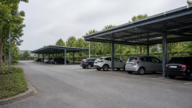 Solarüberdachungen über geordneten Stellplätzen eines alltäglichen Parkplatzes. [Bildinhalt mit KI erstellt]