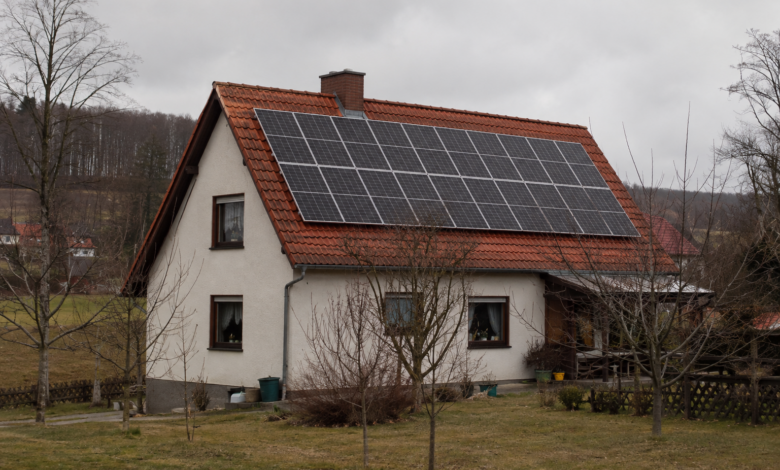 Ländliches Wohnhaus mit einer zusammenhängenden Photovoltaikanlage auf dem Ziegeldach. [Bildinhalt mit KI erstellt]