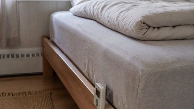 Wasserbett mit textilem Bezug und einem kleinen kabelgebundenen Heizregler am Bettrahmen. [Bildinhalt mit KI erstellt]